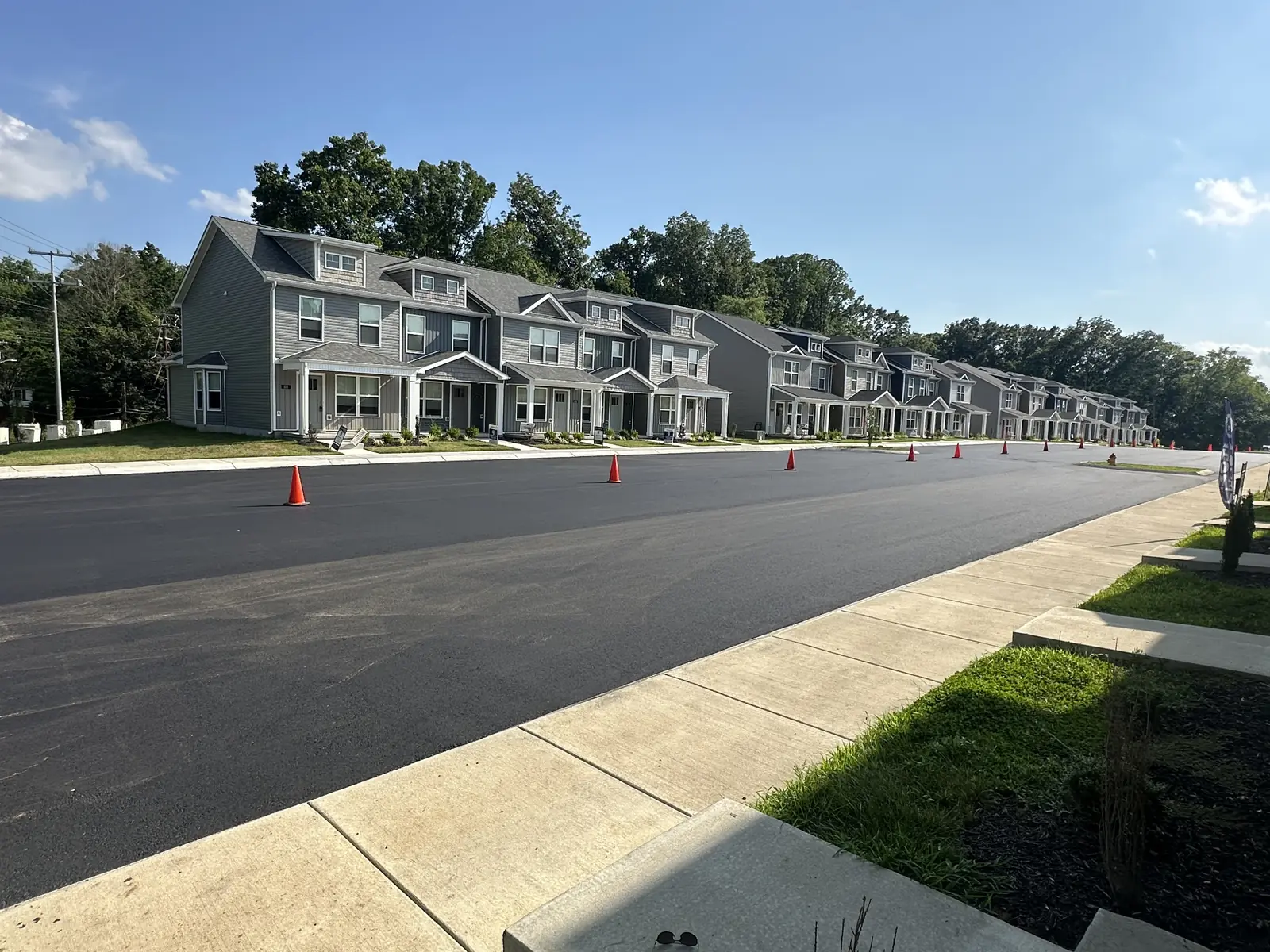 New asphalt pavement in front of a row of townhomes, asphalt driveway paving