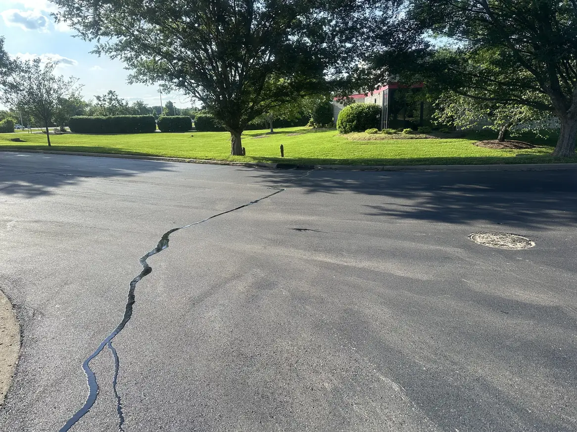 Hot pour sealant filling a long crack in a parking lot, crack sealing
