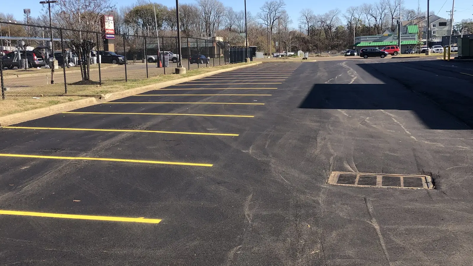 Sealcoated lot with yellow lines, sealcoating and striping