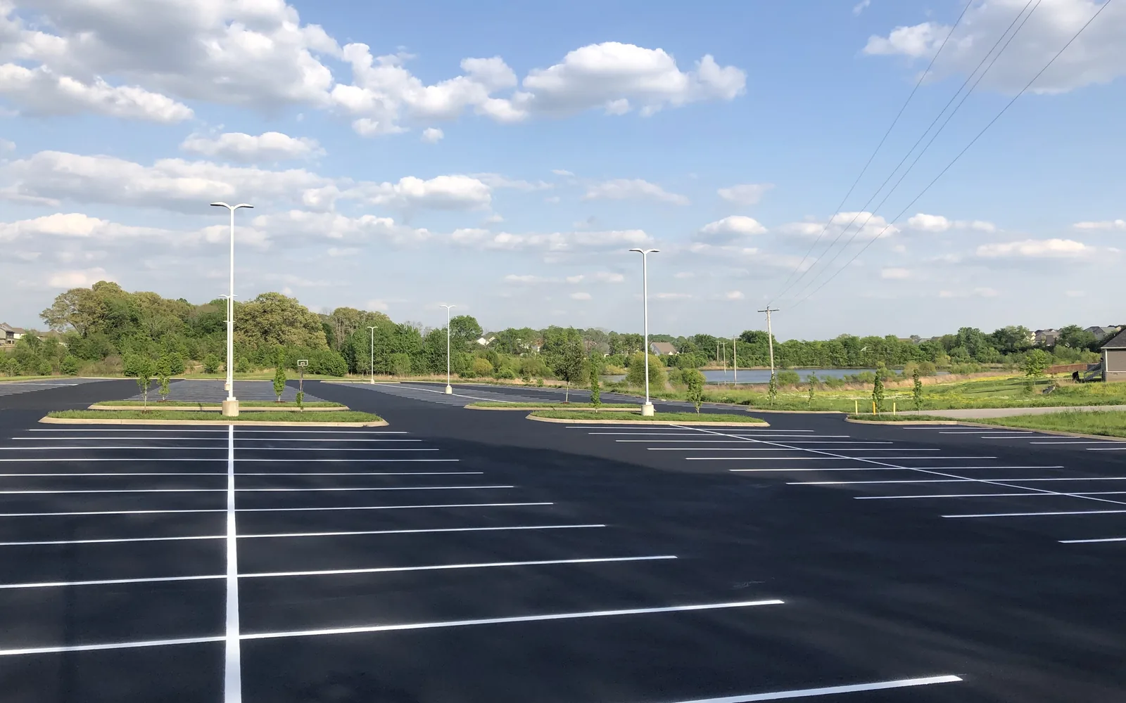New white stall lines across a large parking lot beside a lake, parking lot striping