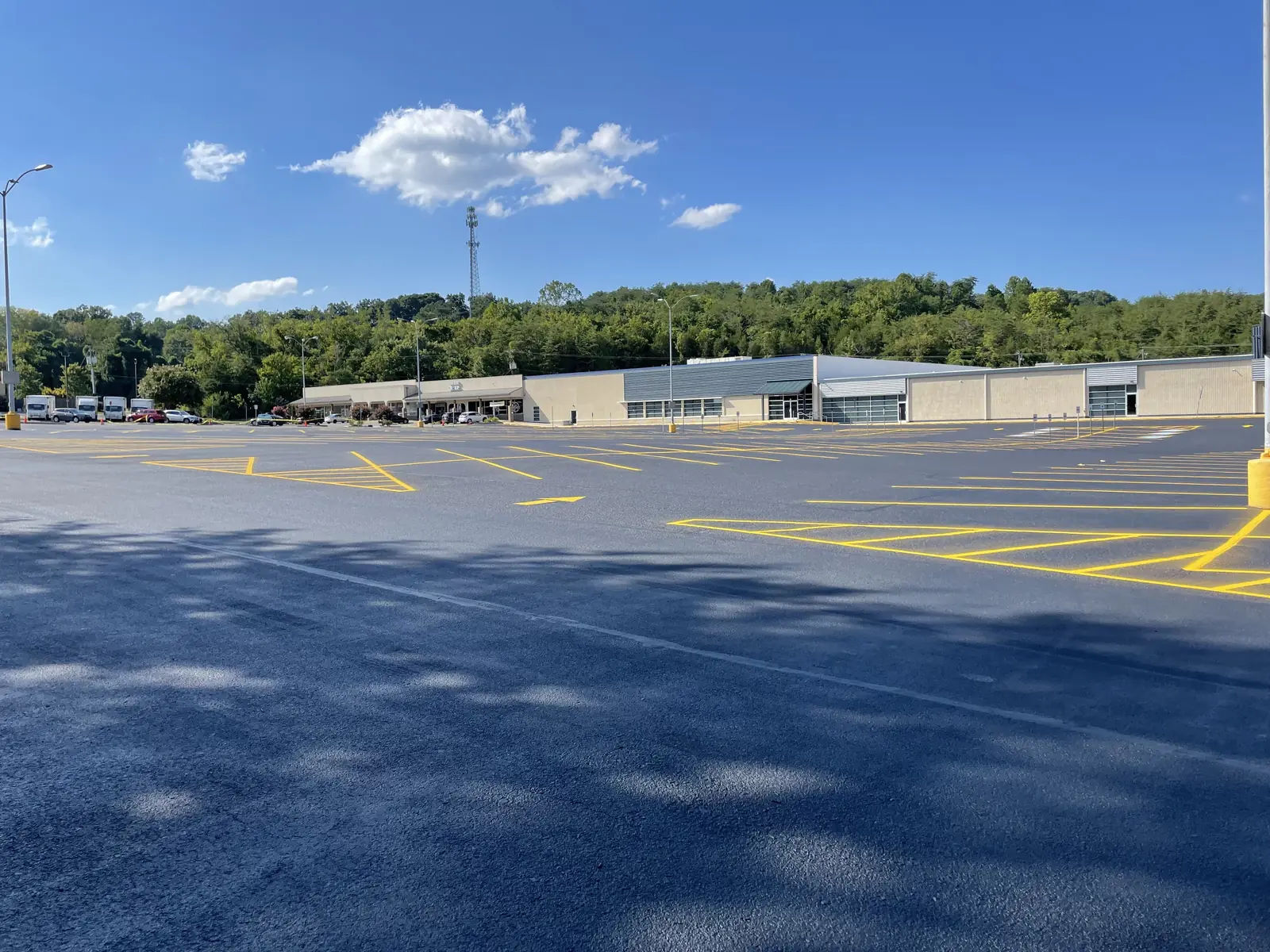 Sealcoated parking lot with fresh yellow striping at a shopping center, sealcoating