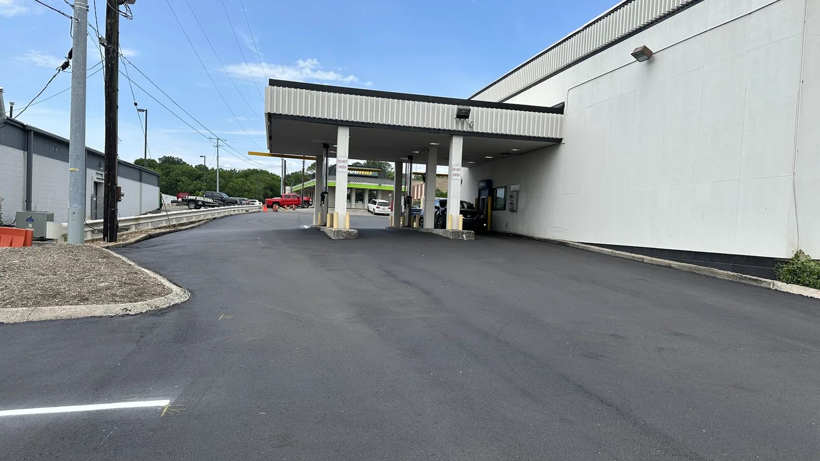 Fresh asphalt around a drive through canopy at a commercial building, asphalt paving